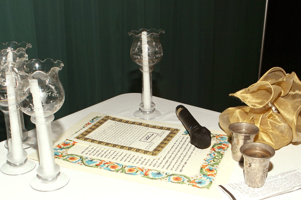 A table with candles and a glass on it